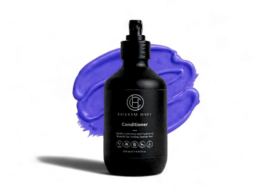Black conditioner bottle with a purple smear on a white background
