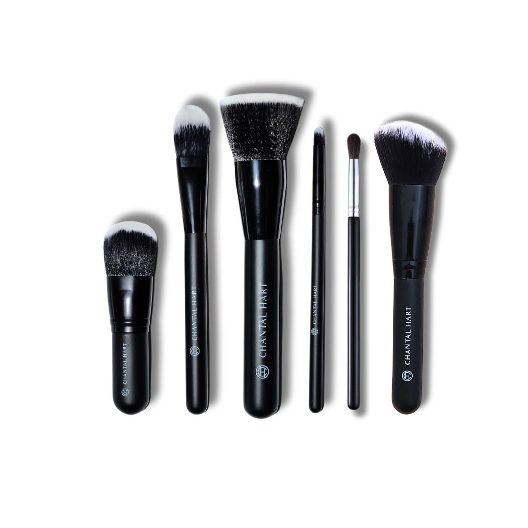 A collection of Chantal Hart makeup brushes with black handles and synthetic bristles, including a buffer brush, flat foundation brush, Kabuki brush, precision bullet brush, eyeshadow brush, and a contour/powder/blush brush.