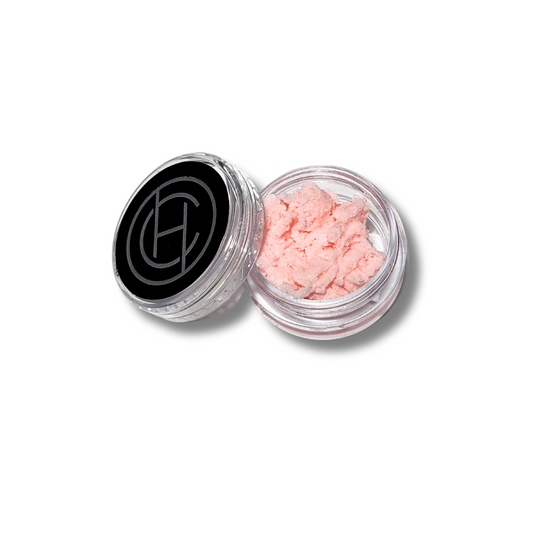 A small, open jar of Chantal Hart Whipped Age Defying Primer with a pink-colored mousse-like product visible inside. The jar has a black lid and a label with the brand logo.