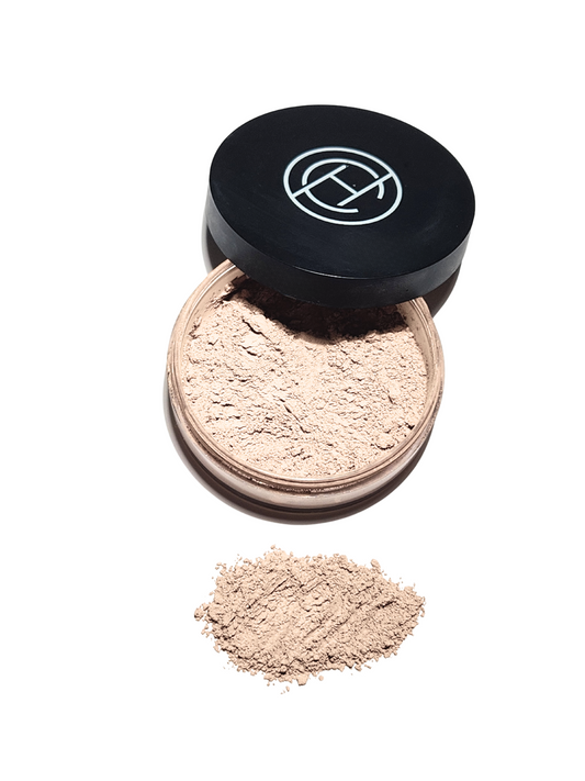 A container of Loose Mineral makeup with the black lid off that has a Chantal Hart Logo.