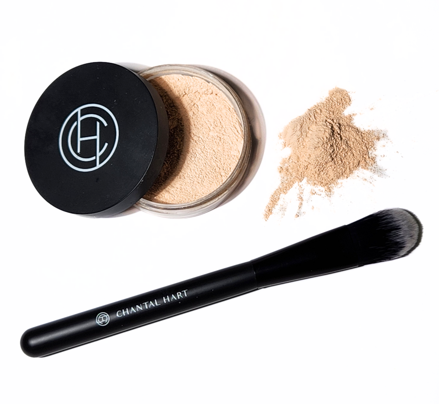 A jar of Chantal Hart Warm Translucent Powder with its lid removed, alongside a black brush. A small amount of powder is scattered outside of the jar.