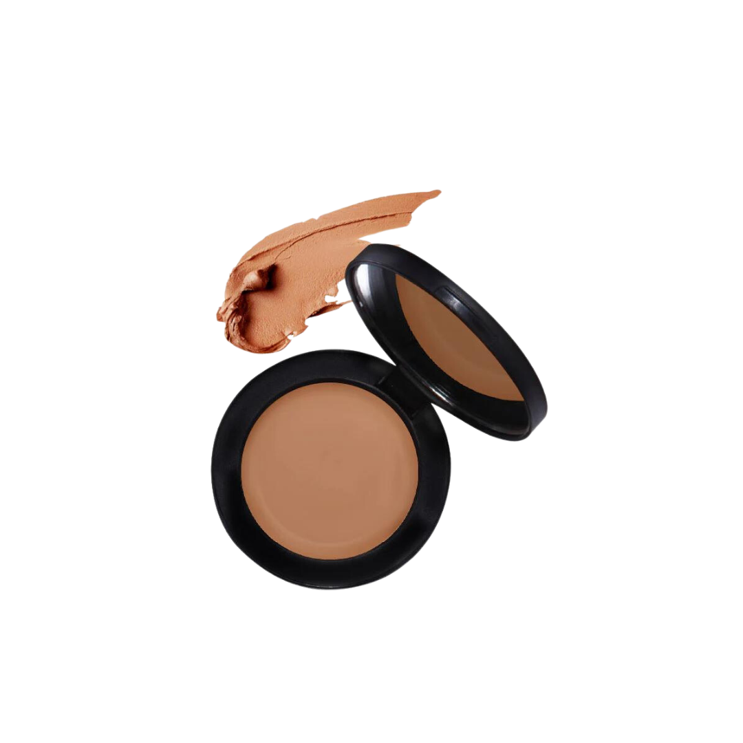 A concealer in an open black compact showcasing the colour.
