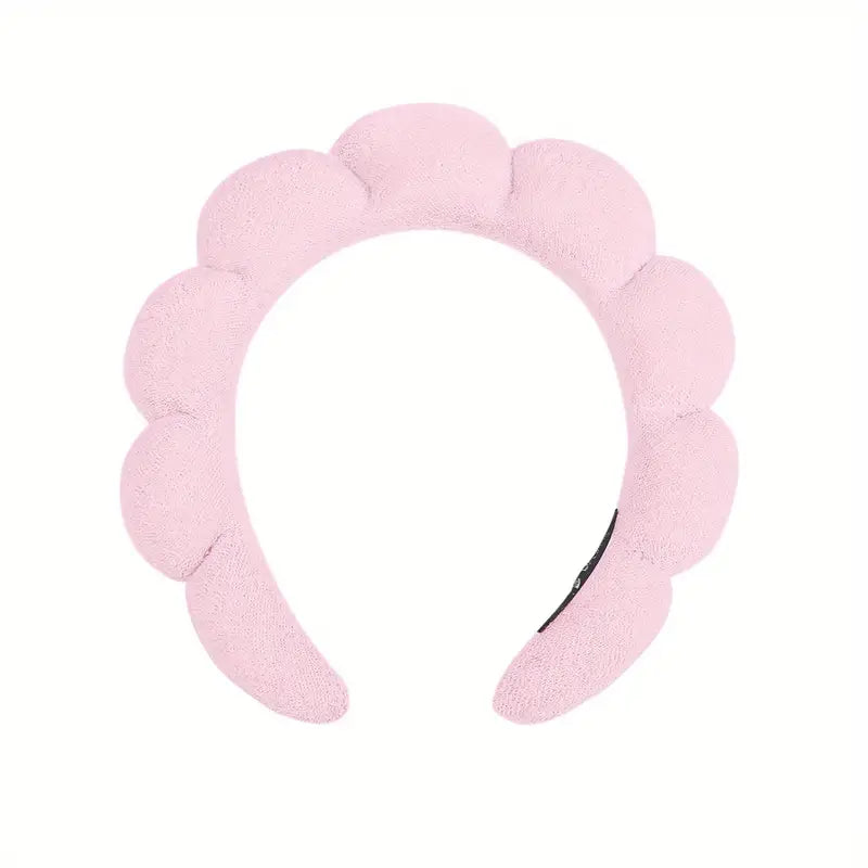 A pink headband designed to keep hair out of the way during skincare or makeup routines.