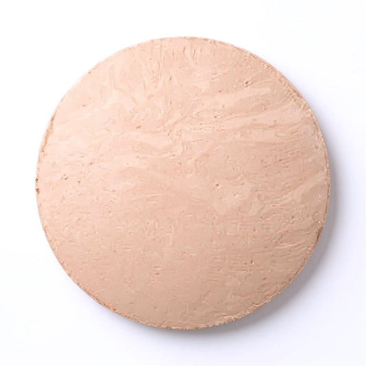 Round light beige foundation dome of makeup on a white background