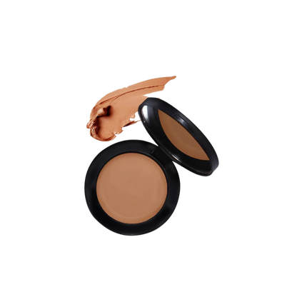 A concealer in an open black compact showcasing the colour.